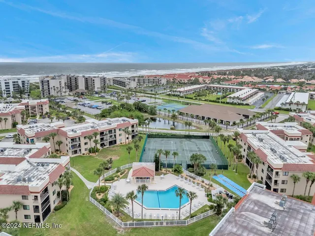 a view of a swimming pool with lawn chairs and plants