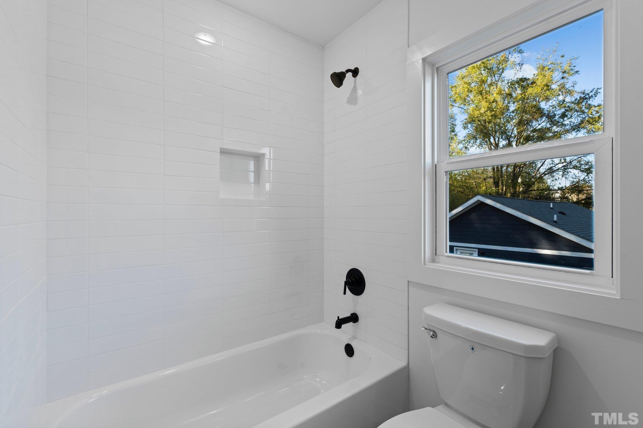 829 Cumberland Street, Unit 100 Raleigh, NC 27610 - Photo 24 of 31 a bathroom with a bathtub and a window