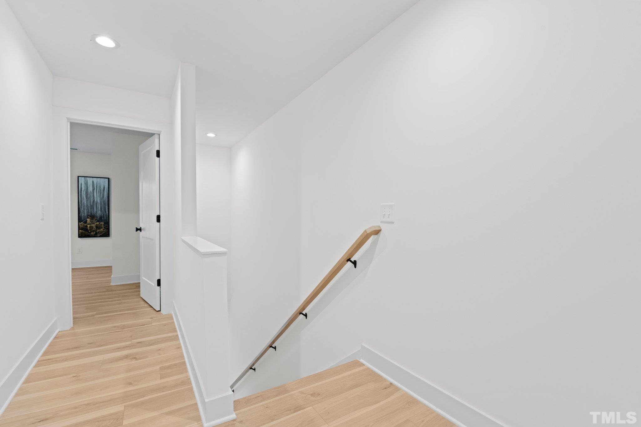 829 Cumberland Street, Unit 100 Raleigh, NC 27610 - Photo 26 of 31 a view of a hallway with wooden floor and staircase