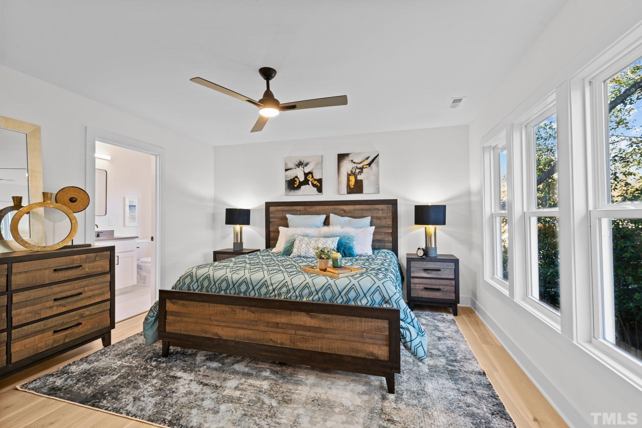 829 Cumberland Street, Unit 100 Raleigh, NC 27610 - Photo 27 of 31 a bedroom with a bed and wooden floor