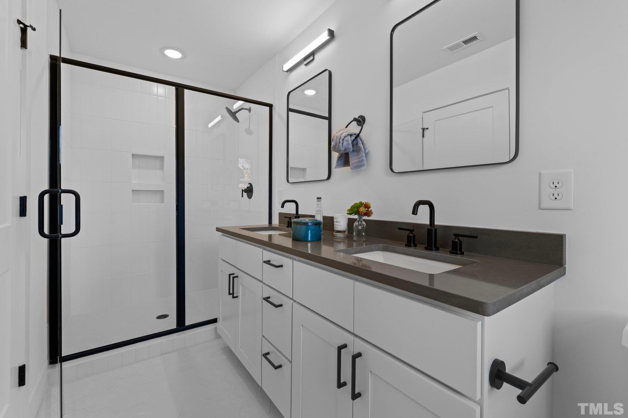 829 Cumberland Street, Unit 100 Raleigh, NC 27610 - Photo 30 of 31 a bathroom with a double vanity sink mirror and double