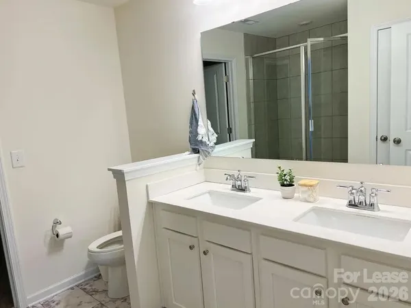a bathroom with a granite countertop sink a toilet and a mirror