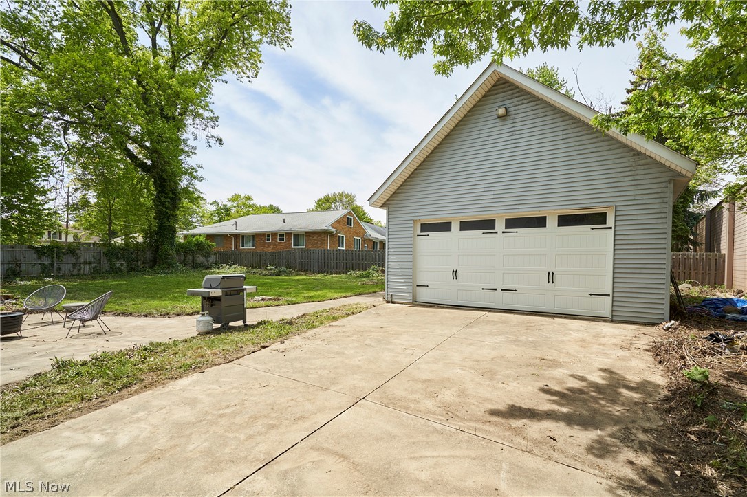 780 Bates Road Rocky River, OH 44116 - Photo 30 of 35 Detached garage featuring light blue siding and a white sectional overhead door with decorative hardware and transom windows