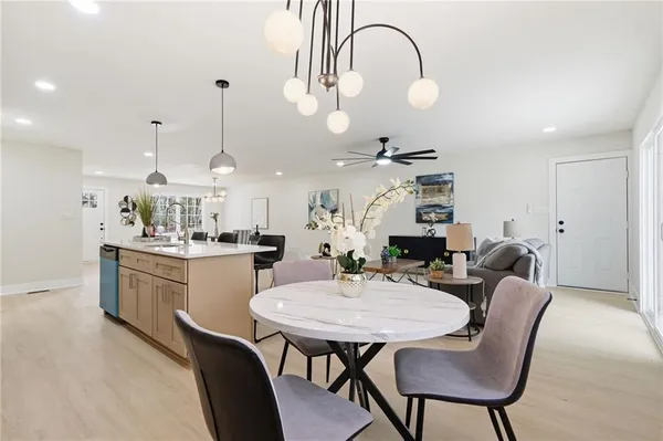 a large kitchen with kitchen island a stove a sink a dining table and chairs