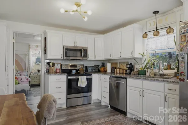 a kitchen with kitchen island granite countertop a sink cabinets and stainless steel appliances