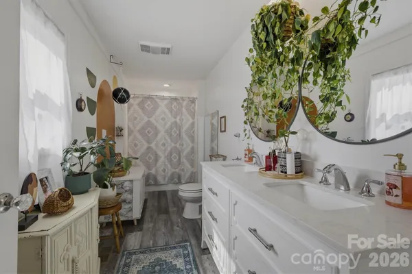 a bathroom with a sink and mirror with toilet