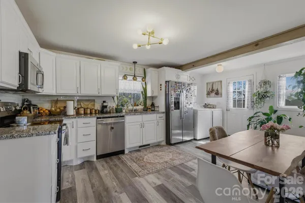 a kitchen with stainless steel appliances granite countertop a stove refrigerator and cabinets