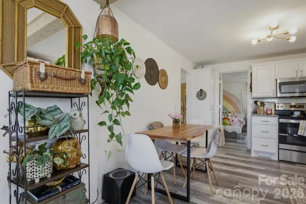 a dining room filled chandelier and wooden floor