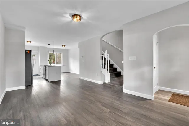 a view of a livingroom with wooden floor and a kitchen space
