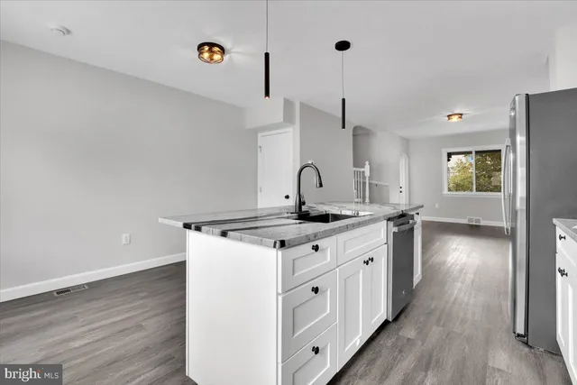 a kitchen with a sink cabinets and wooden floor