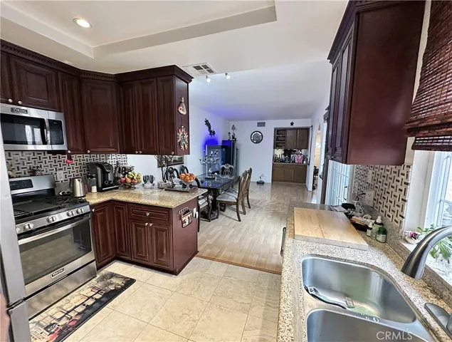 a kitchen with stainless steel appliances granite countertop a sink stove and cabinets