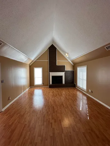 a big room with wooden floor and windows