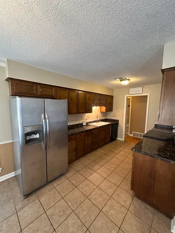 a kitchen with stainless steel appliances granite countertop a refrigerator and a sink