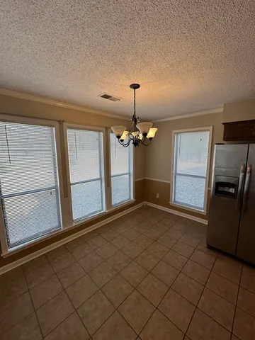 a view of a livingroom with a chandelier fan and windows