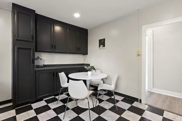 a kitchen with a checkered floor and white cabinets
