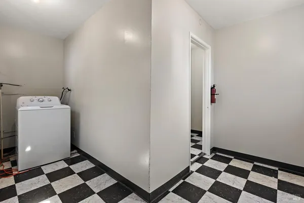 a view of a storage & utility room with a washing machine