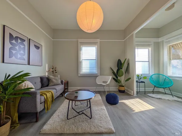 a living room with furniture a window and a potted plant