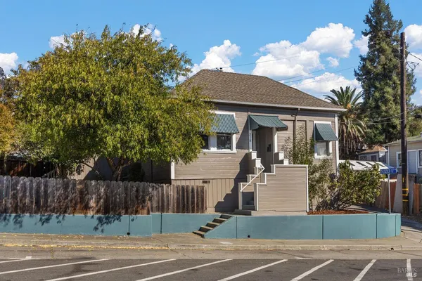 a view of a house with a backyard and a tree