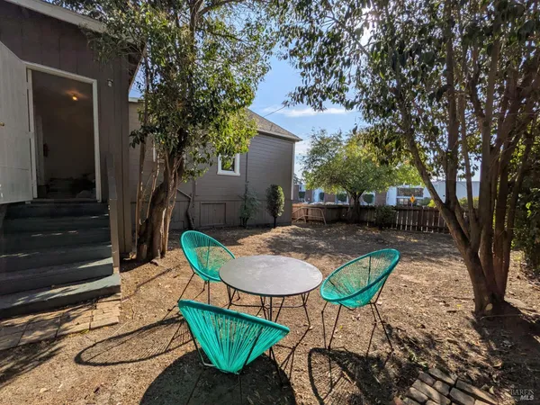 a backyard of a house with table and chairs