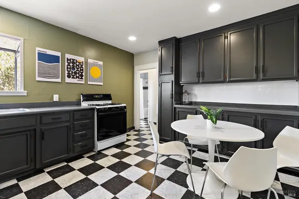 a kitchen with a sink chairs and refrigerator