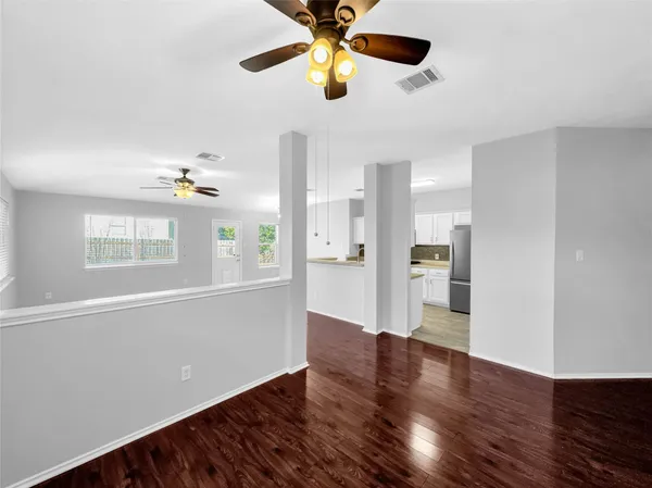 a view of an empty room with window and wooden floor
