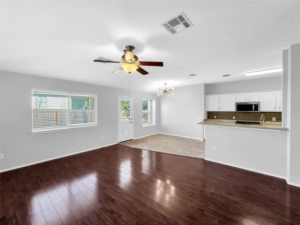 a view of open kitchen with wooden floor and black appliances