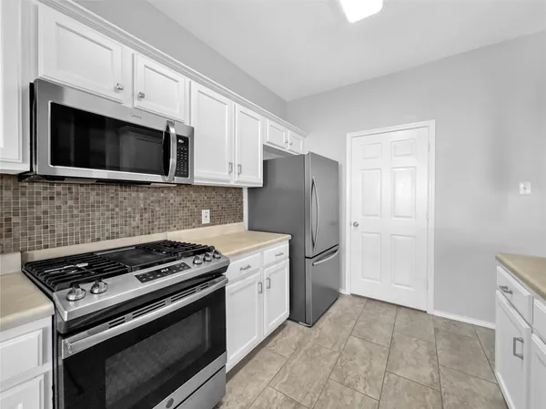 a kitchen with stainless steel appliances a stove a microwave and cabinets