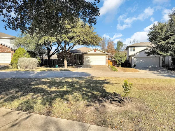 a view of a yard with a large tree in front of the house