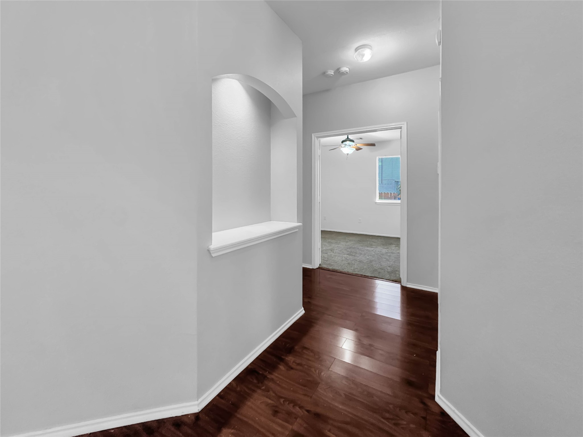 1032 Tudor House Road Pflugerville, TX 78660 - Photo 9 of 32 a view of a hallway with wooden floor and a bathroom