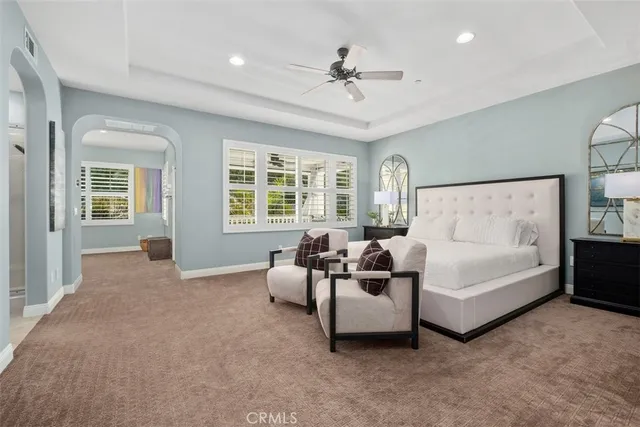 a spacious bedroom with a bed and glass windows
