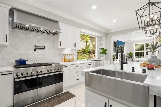 a kitchen with stainless steel appliances granite countertop a sink stove and cabinets
