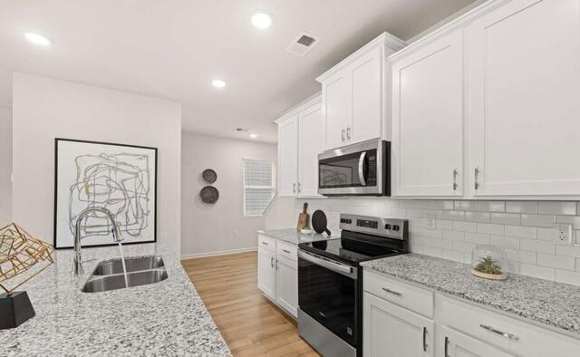 1260 Riverstone Road Jonesboro, GA 30236 - Photo 8 of 45 a kitchen with stainless steel appliances granite countertop a stove a sink and a microwave