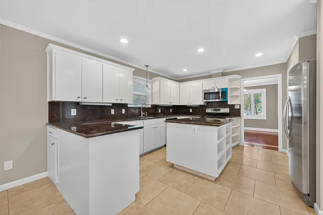a large kitchen with stainless steel appliances granite countertop a stove a sink and a refrigerator