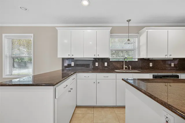 a kitchen with stainless steel appliances granite countertop a sink a stove and white cabinets