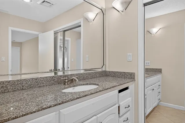 a bathroom with a granite countertop sink and a mirror