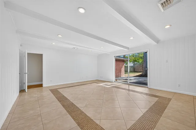 an empty room with entrance and windows