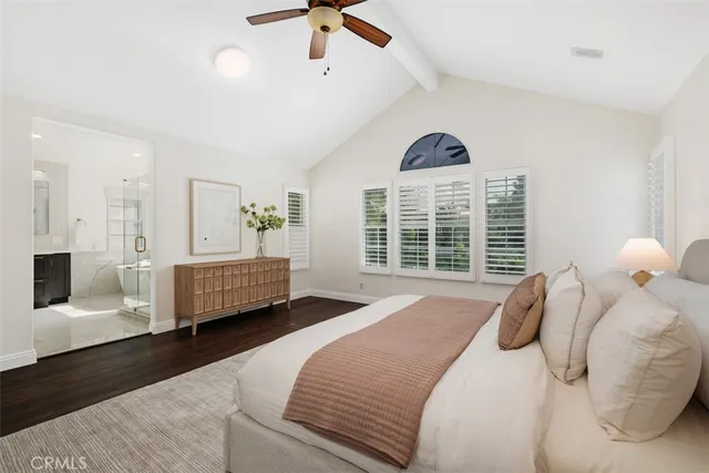 a spacious bedroom with a bed a window and a chandelier