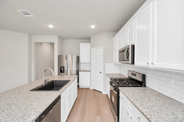 a kitchen with stainless steel appliances a refrigerator sink and microwave
