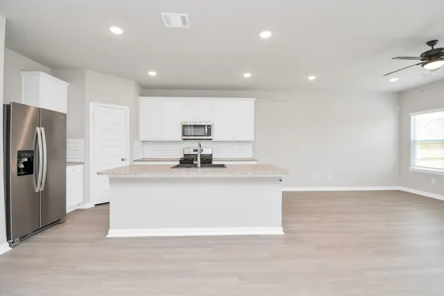 a view of kitchen with refrigerator cabinets and wooden floor