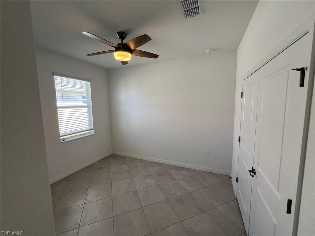 2320 Dragonfruit Way Naples, FL 34120 - Photo 14 of 33 Empty room featuring visible vents, ceiling fan, baseboards, and light tile patterned floors