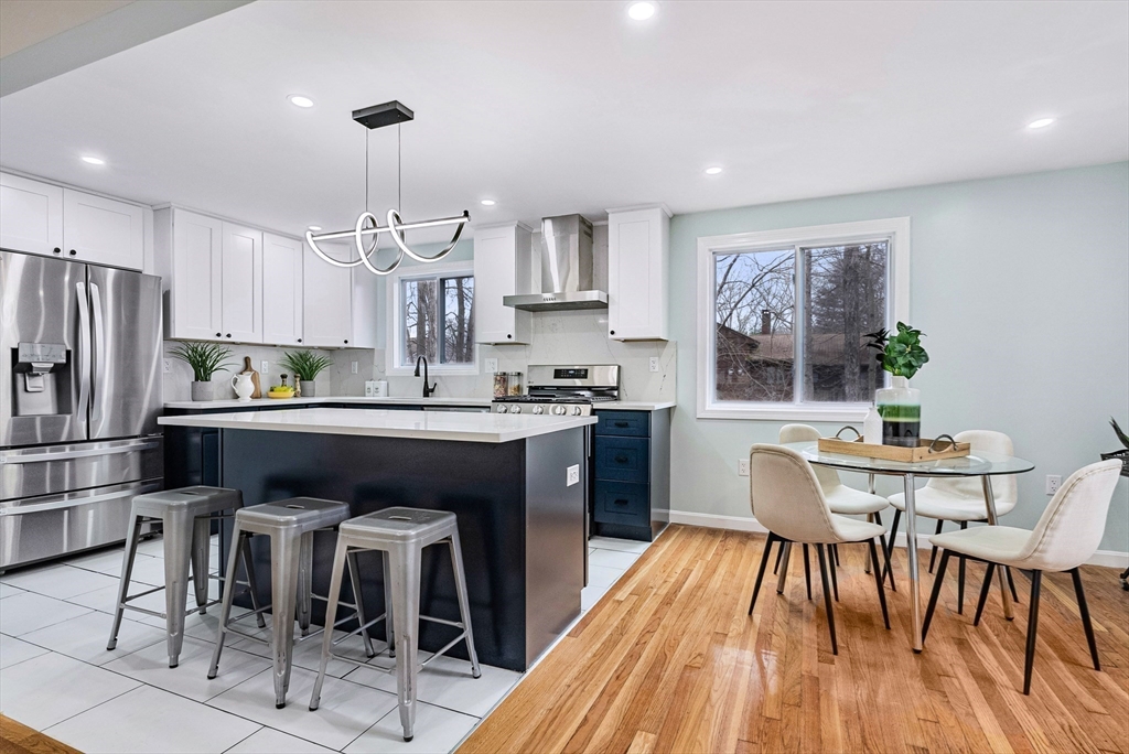 76 Sunset Drive Brockton, MA 02301 - Photo 8 of 32 a kitchen with stainless steel appliances granite countertop a dining table chairs refrigerator and cabinets