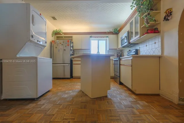 a view of a kitchen with fridge and wooden floor
