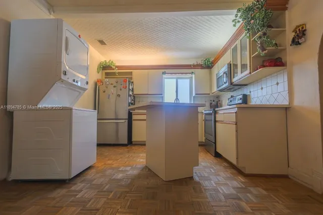 a view of a kitchen with fridge and wooden floor