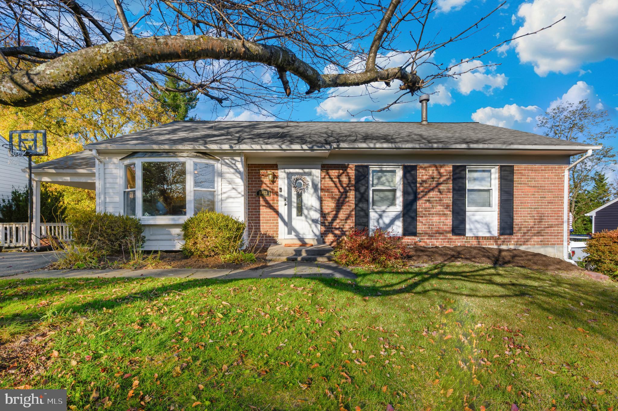 Charming brick home with vibrant landscaping.