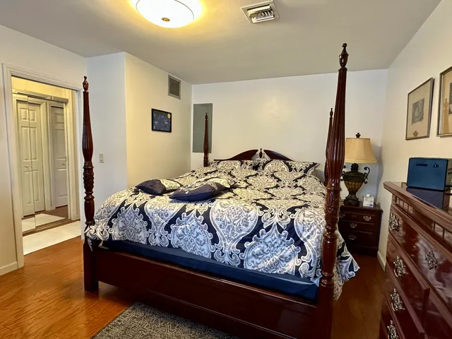 a bedroom with a bed and a flat tv screen on the dresser
