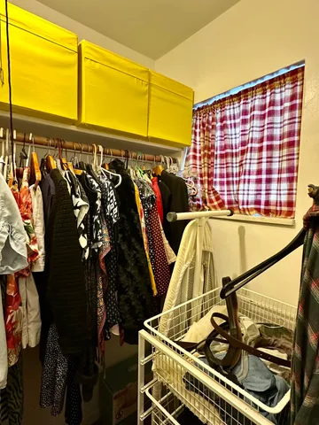 a view of walk in closet with clothes and shoes