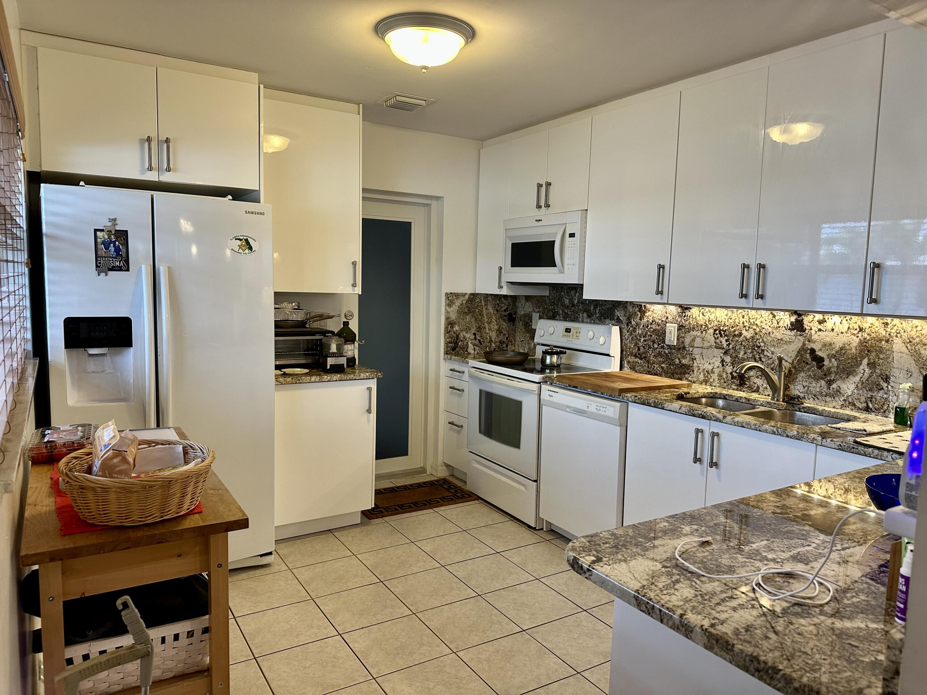 728 Ridge Road, Unit 35 Lantana, FL 33462 - Photo 2 of 35 a kitchen with stainless steel appliances kitchen island granite countertop a stove and a refrigerator