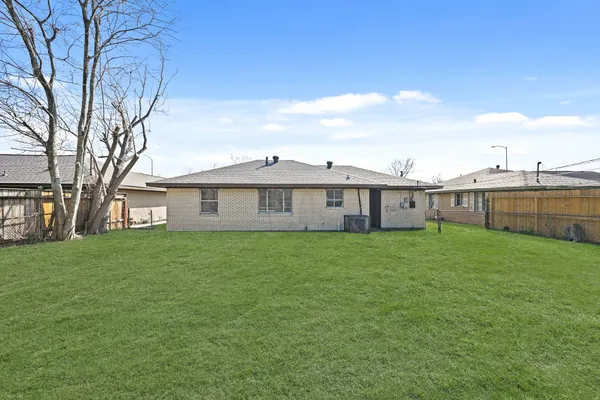 a view of a yard in front of a house with a large tree