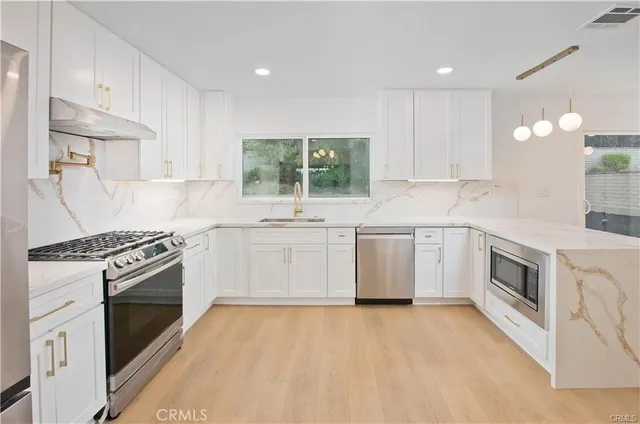 a view of a kitchen with a sink and chandelier