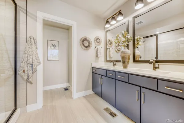 a bathroom with a double vanity sink mirror and shower